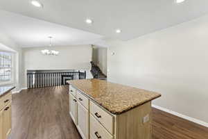 Kitchen with a kitchen island, light brown cabinetry, dark wood-style floors, pendant lighting, and recessed lighting