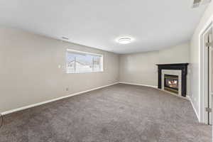 Unfurnished living room with a fireplace and carpet