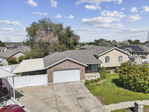 Split level home featuring a garage, a residential view, concrete driveway, brick siding, and roof with shingles