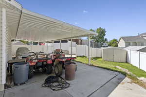 Fenced backyard with a storage unit and a patio area