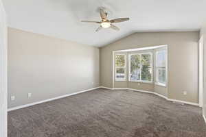 Unfurnished room featuring lofted ceiling, carpet floors, and a ceiling fan