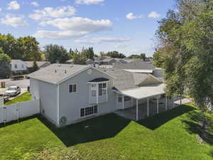 Back of property featuring a patio area, a shingled roof, a residential view, and a gate