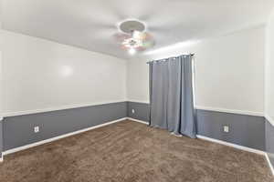 Empty room featuring carpet and a ceiling fan