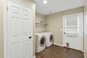 Washroom featuring dark wood-style flooring, washing machine and clothes dryer, and recessed lighting