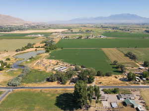 Aerial view of property's location featuring rural landscape, a mountainous background, and large plots for crops