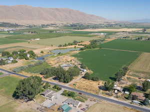 Aerial view of property and surrounding area featuring rural landscape and a water and mountain view