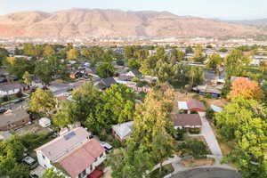 Aerial view of property and surrounding area with a mountainous background and nearby suburban area