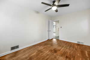 Unfurnished room with wood finished floors and a ceiling fan