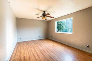 Empty room with light wood-style flooring, a textured ceiling, and ceiling fan