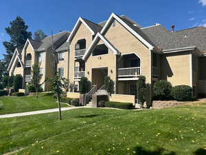 View of front of house featuring a balcony and a front yard