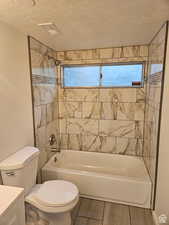 Bathroom featuring tub / shower combination, a textured ceiling, and vanity