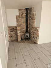 Detailed view of wood finish floors, a textured ceiling, and a wood stove