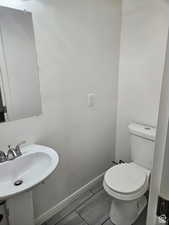 Half bathroom featuring baseboards and toilet