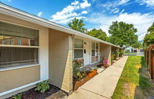 Property entrance with concrete block siding and a porch