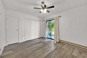 Bedroom showing closet door, utility closet, and sliding glass door out to back patio.