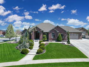 View of front facade with brick siding, roof with shingles, a garage, and concrete driveway