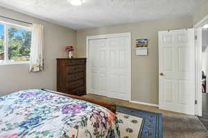 Bedroom with a closet, a textured ceiling, and carpet flooring