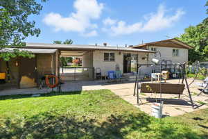 Back of house featuring a patio area, brick siding, and a lawn
