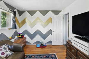 Living room with dark wood-type flooring and a textured ceiling