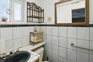 Bathroom featuring tile walls and a sink