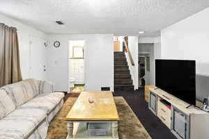 Living room with a textured ceiling and stairs