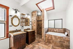 Primary bathroom en-suite with a shower stall, a bath, two vanities, tons of natural light.