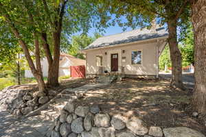 Bungalow with a chimney, a shingled roof, and stucco siding