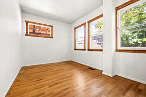 Main floor bedroom featuring light wood-style floors and healthy amount of natural light