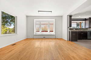 Living room and dining area featuring light wood-style floors and baseboards