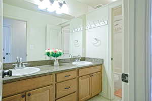 Bathroom featuring double vanity and  shower combination.