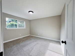 Unfurnished bedroom featuring carpet and baseboards