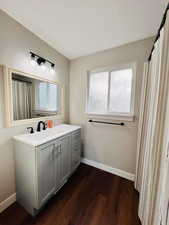 Full bathroom featuring vanity, dark wood-style flooring, a textured ceiling, and a shower with curtain