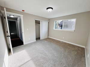 Unfurnished bedroom featuring a closet and carpet floors