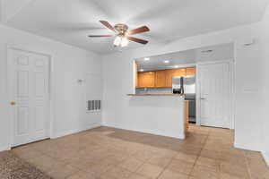 Unfurnished living room featuring a ceiling fan, light tile patterned floors, and recessed lighting