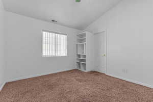 Unfurnished bedroom with vaulted ceiling, carpet floors, and a ceiling fan