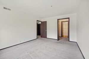Unfurnished bedroom featuring light colored carpet and baseboards
