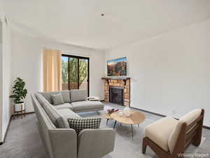 Carpeted living area with a stone fireplace and baseboards