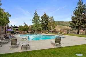 Community pool with a patio and a mountain view