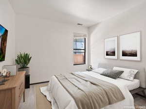 Bedroom featuring light carpet and baseboards