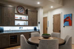 Dining area featuring beverage cooler, light wood finished floors, and recessed lighting