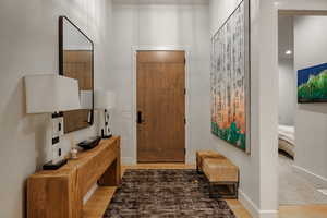 Foyer entrance with light wood-style flooring and baseboards