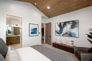 Bedroom with lofted ceiling, light carpet, recessed lighting, wood ceiling, and ensuite bath