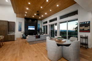 Dining space featuring wood ceiling, recessed lighting, a towering ceiling, light wood-style floors, and ceiling fan
