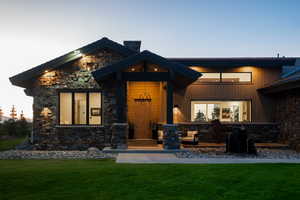 View of front of home featuring stone siding and a front lawn
