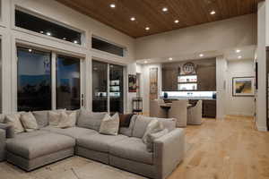 Living area featuring light wood-style flooring, recessed lighting, and wooden ceiling