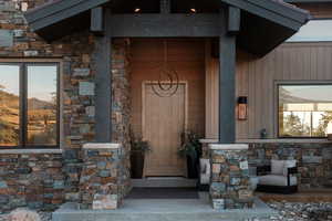 Property entrance with stone siding and a porch