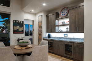 Dining room with wine cooler, light wood finished floors, wet bar, and recessed lighting