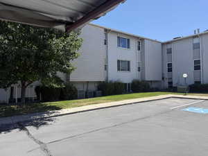 View of building exterior featuring uncovered parking