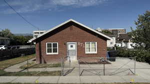 Bungalow-style house with brick siding and a gate