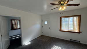 Carpeted foyer entrance featuring a ceiling fan and baseboards